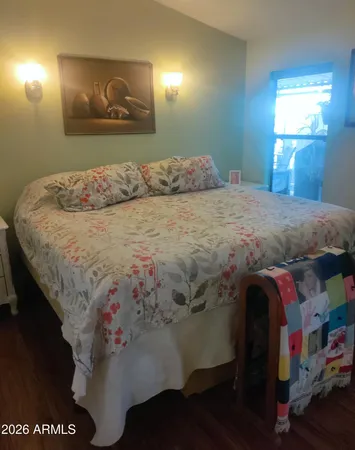a bedroom with a bed and a painting on the wall