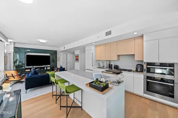 a kitchen with stainless steel appliances a stove and white cabinets
