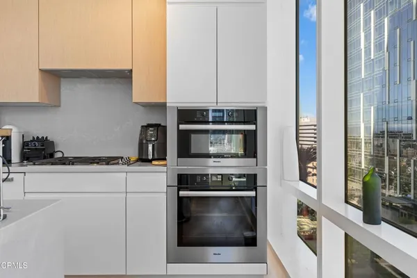 a large white kitchen with sink and cabinets
