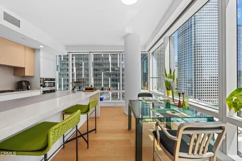 a kitchen with a dining table chairs and white appliances