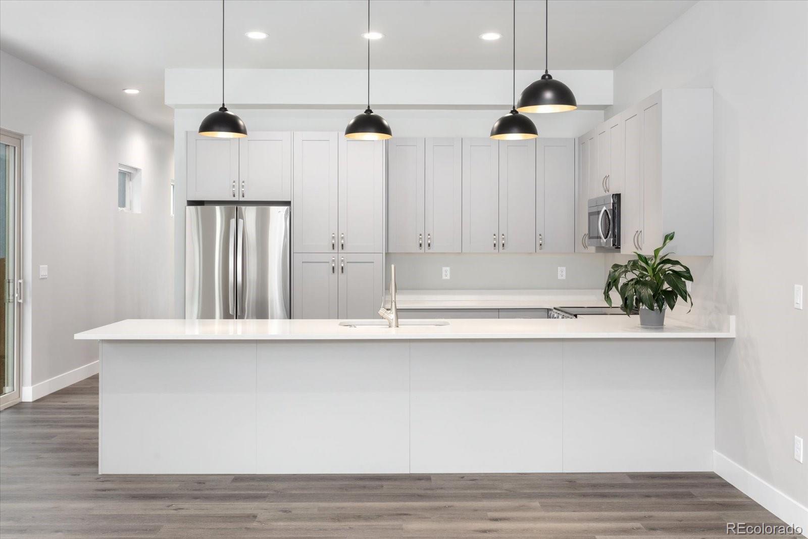 a large kitchen with a wooden floor and cabinets