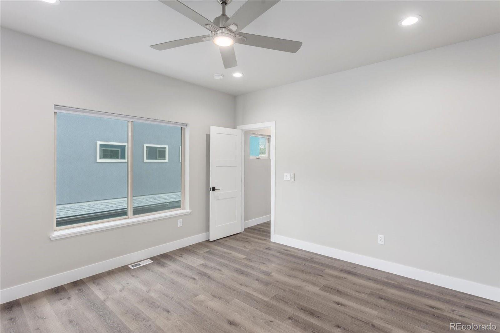 128 Southside Loop Salida, CO 81201 - Photo 14 of 20 an empty room with wooden floor fan and windows