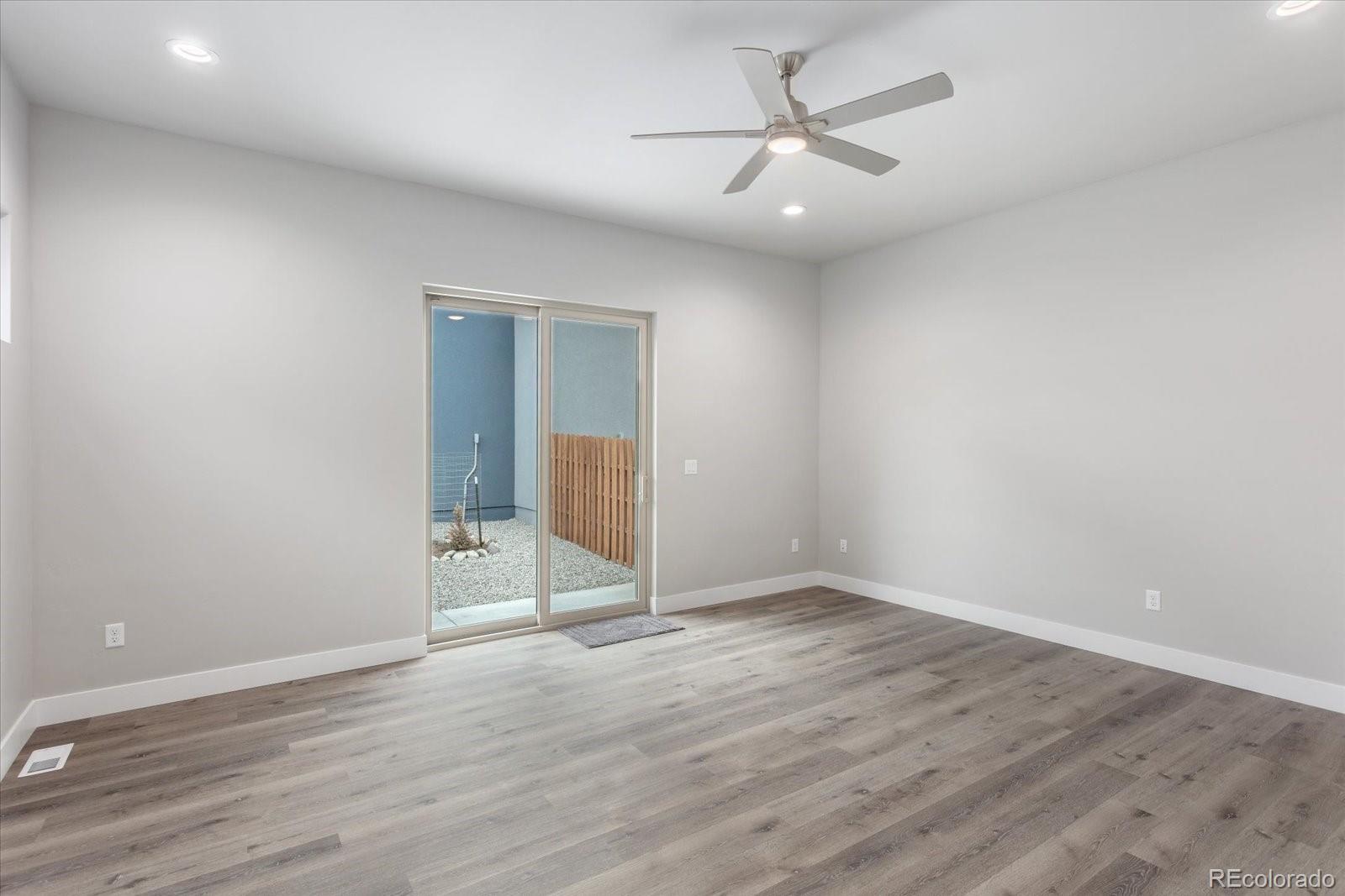 128 Southside Loop Salida, CO 81201 - Photo 9 of 20 an empty room with wooden floor and ceiling fan