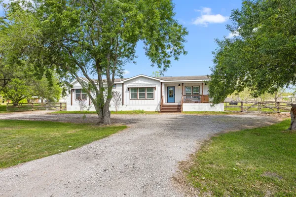 a front view of a house with a garden and trees