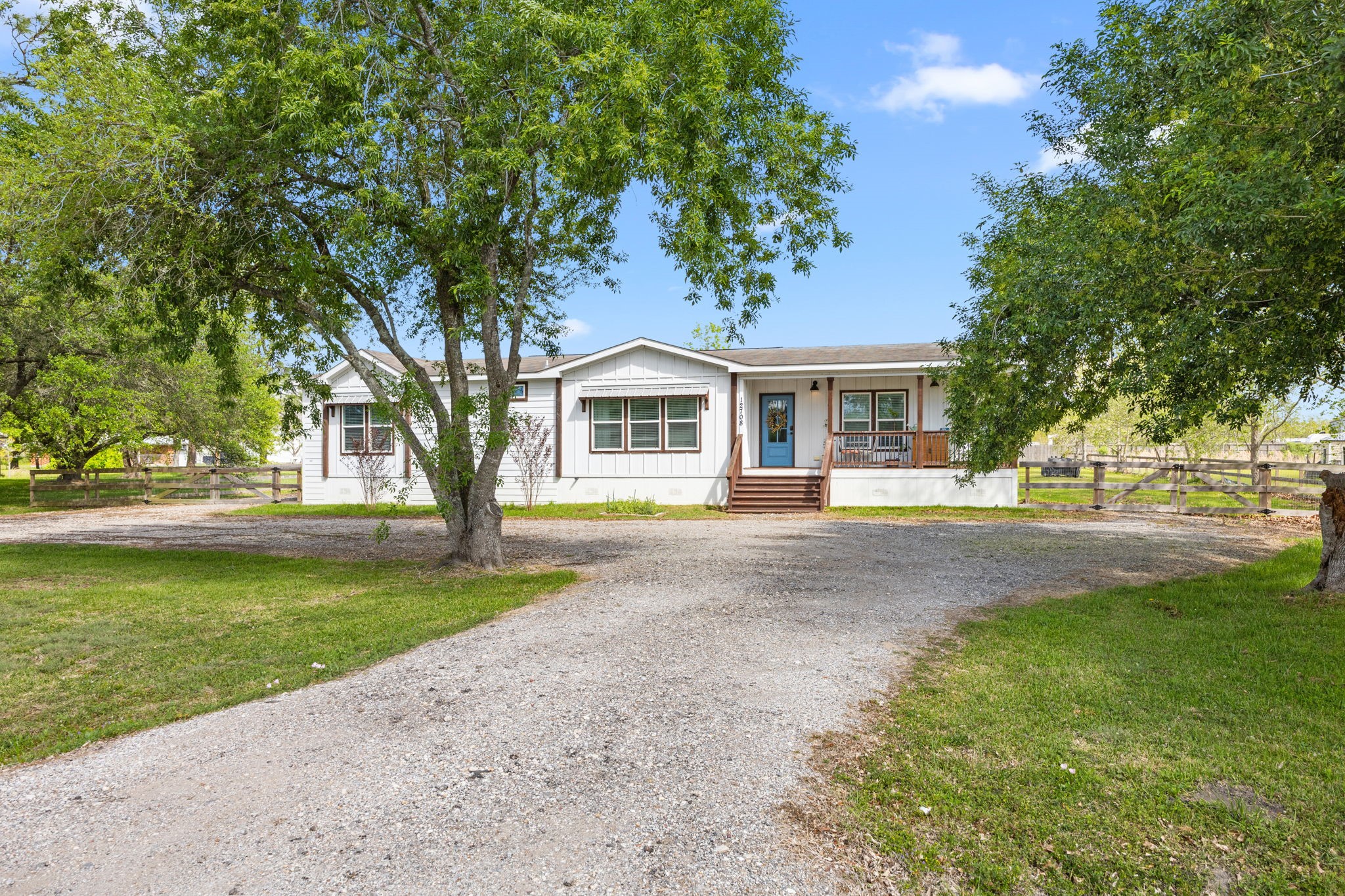 a front view of a house with a garden and trees