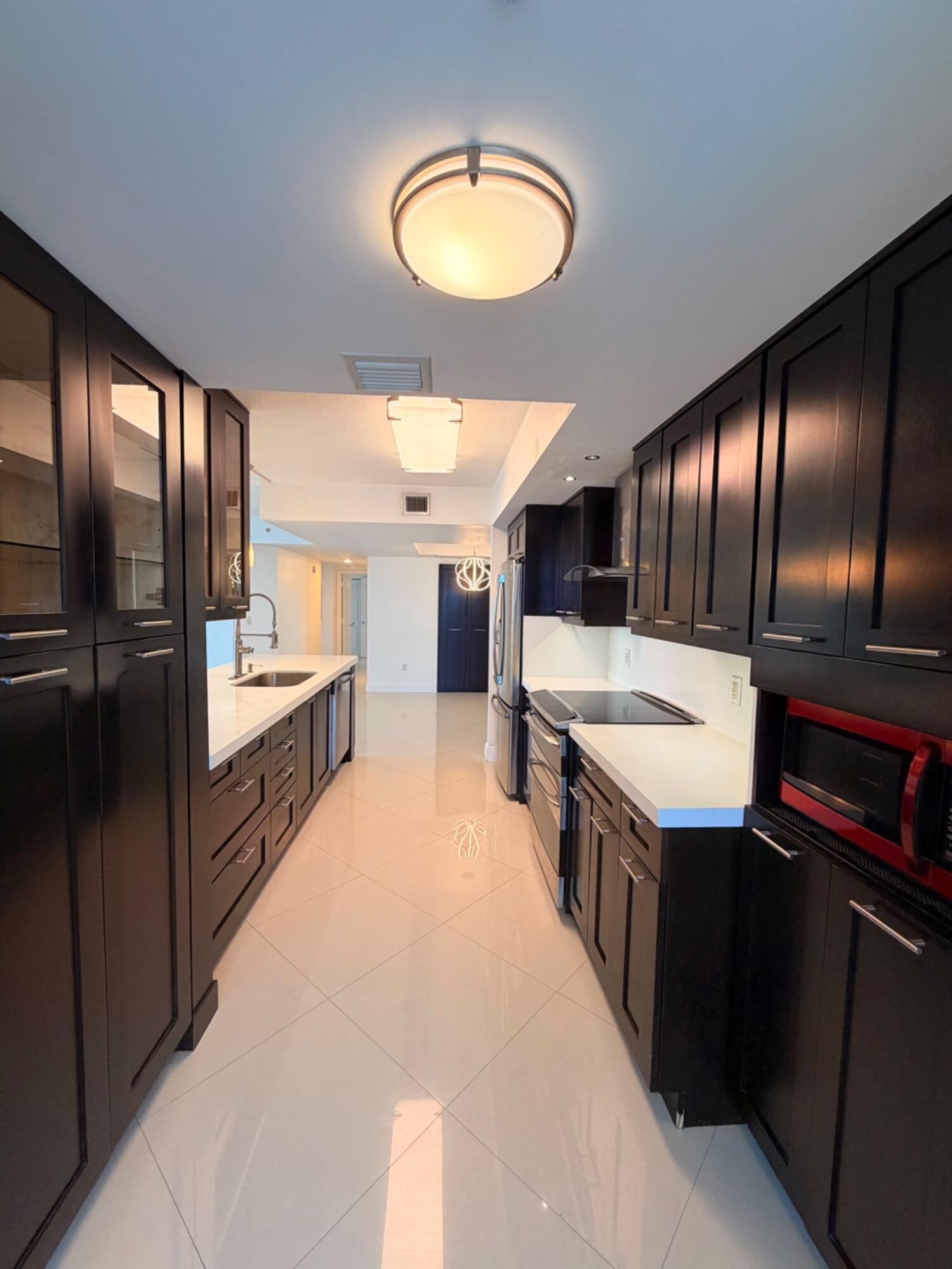 3232 Coral Way, Unit 1601 Miami, FL 33145 - Photo 19 of 27 a large kitchen with a large counter top stainless steel appliances and cabinets