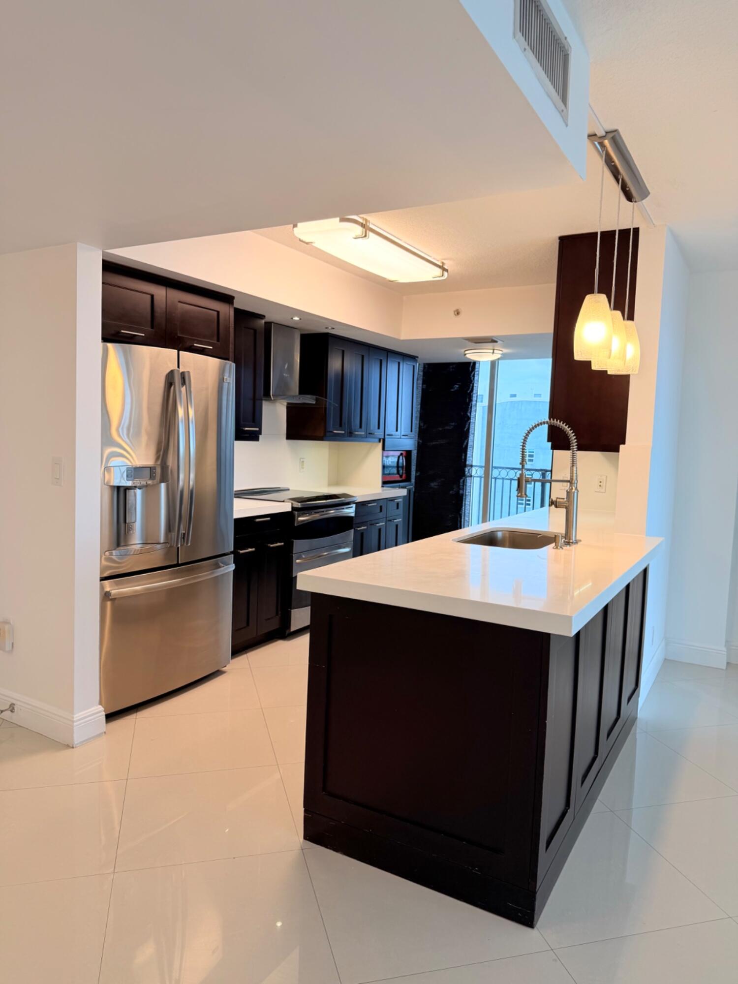 3232 Coral Way, Unit 1601 Miami, FL 33145 - Photo 6 of 27 a kitchen with stainless steel appliances a stove a microwave a sink and a refrigerator