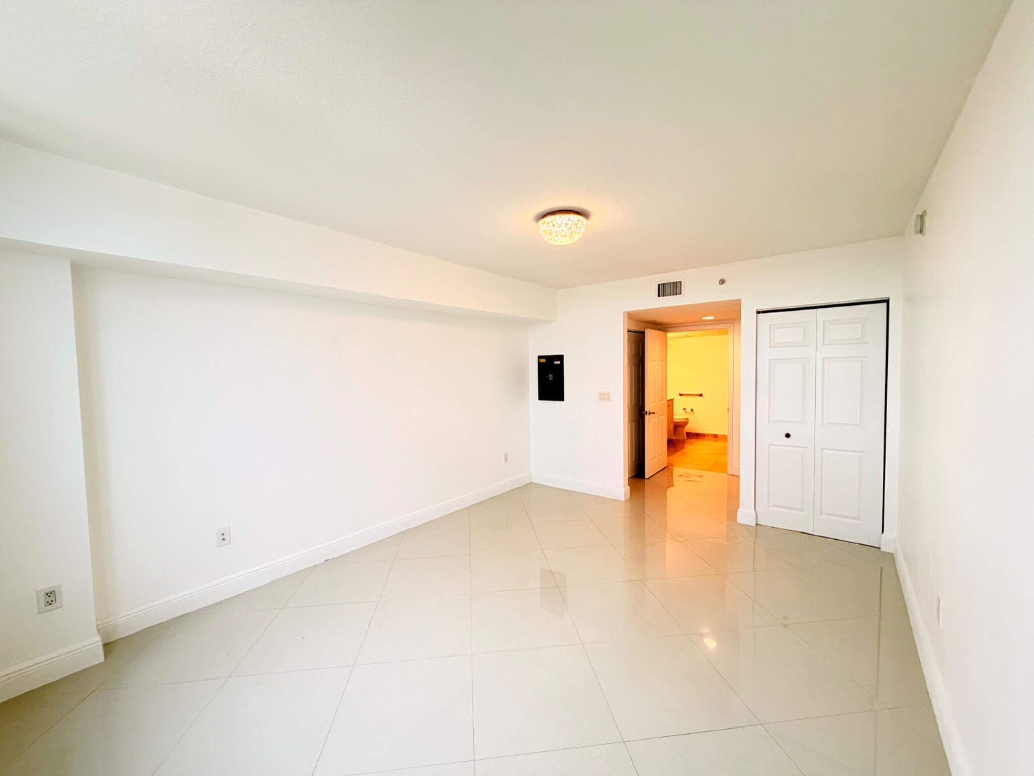 3232 Coral Way, Unit 1601 Miami, FL 33145 - Photo 7 of 27 an empty room with a gallery and wooden floor