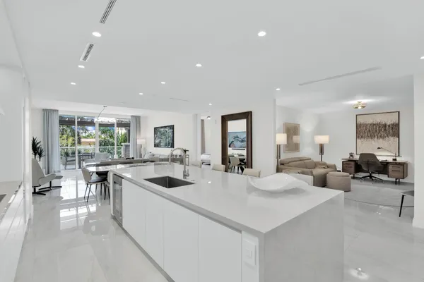 a kitchen with white cabinets and chairs