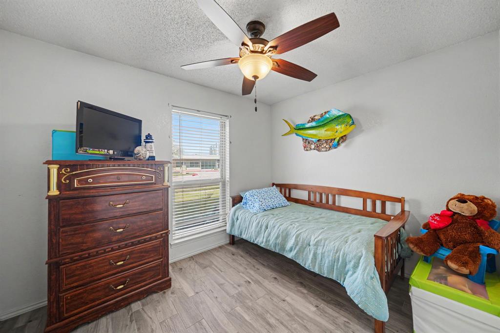 7624 Maple Hill Road Watauga, TX 76148 - Photo 10 of 20 Wood-finish flooring with neutral wall paint, a window featuring horizontal blinds, and a ceiling fan with integrated lighting
