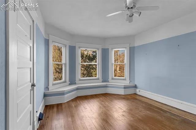 a view of an empty room with closet and a window