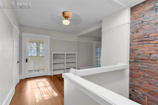 a view of a hallway with wooden floor windows and a living room