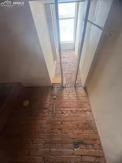 a view of a room with wooden floor and a window