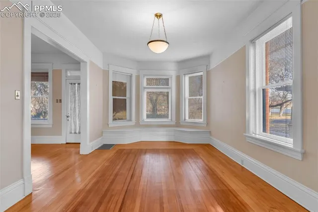 a view of empty room with wooden floor and fireplace