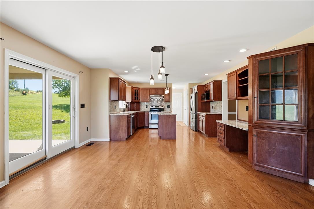 590 Fehr Road Nazareth, PA 18064 - Photo 15 of 79 Gleaming hardwood floors run through this open kitchen featuring classic wooden cabinetry and sliding glass doors.