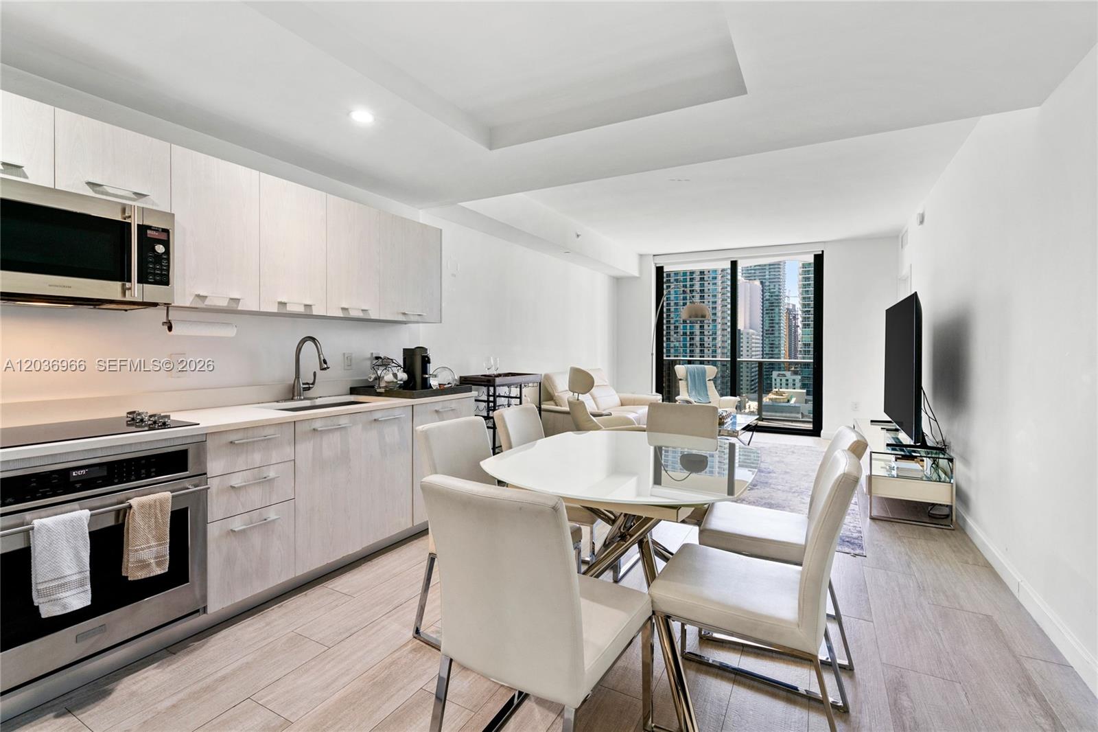 55 Southwest 9th Street, Unit 1904 Miami, FL 33130 - Photo 2 of 66 a kitchen with stainless steel appliances a stove a sink dishwasher a microwave oven with a dining table and chairs
