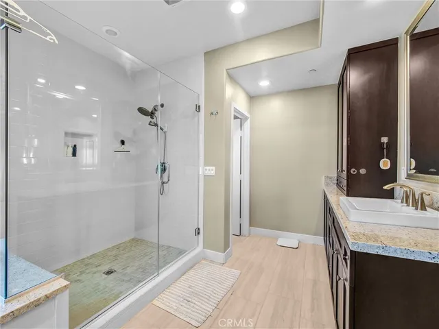 a bathroom with a granite countertop sink mirror and shower