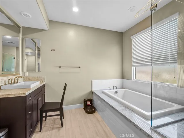 a bathroom with a tub a sink and a mirror