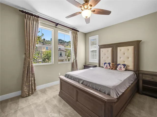 a bed sitting in a spacious bedroom next to a window