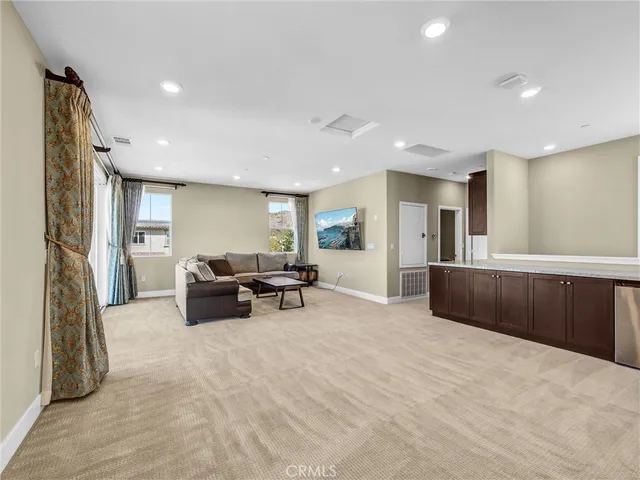 a living room with furniture and a refrigerator