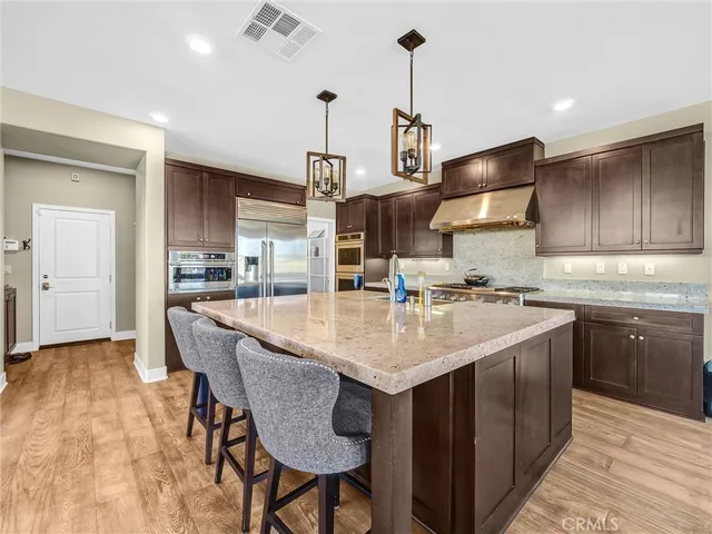 a kitchen with sink a center island and stainless steel appliances