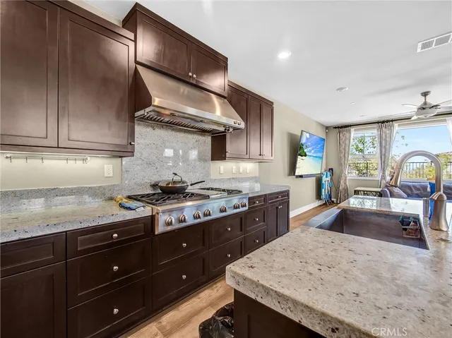 a kitchen with granite countertop wooden cabinets and a stove