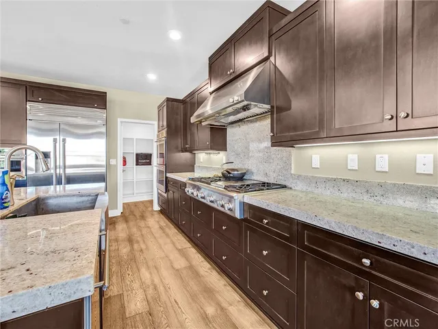 a kitchen with stainless steel appliances granite countertop a stove a sink and a refrigerator