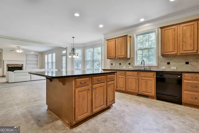 a living room with furniture and a large window with kitchen view