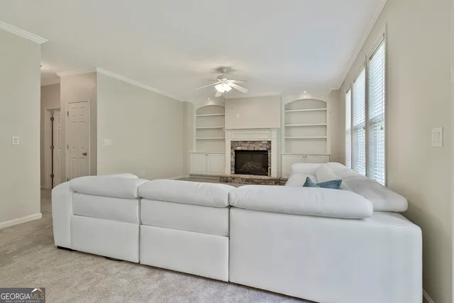 a view of an empty room with a chandelier fan