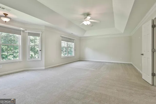 an empty room with windows and ceiling fan