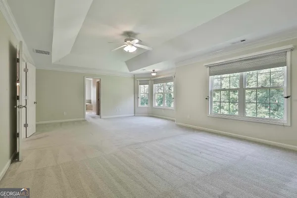 a view of an empty room with a ceiling fan and window