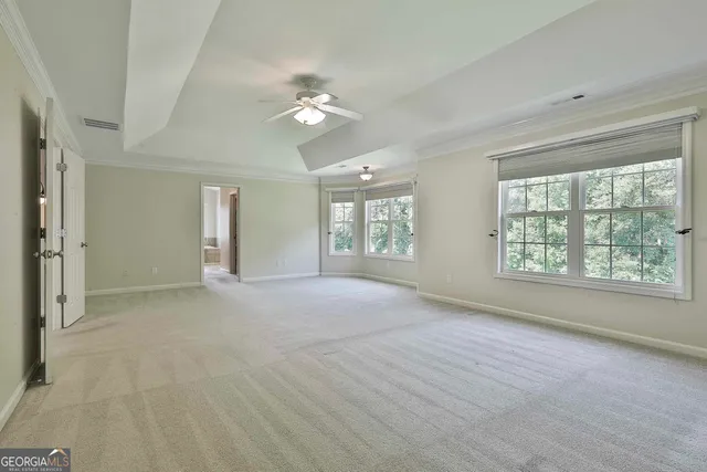 a view of an empty room with a ceiling fan and window