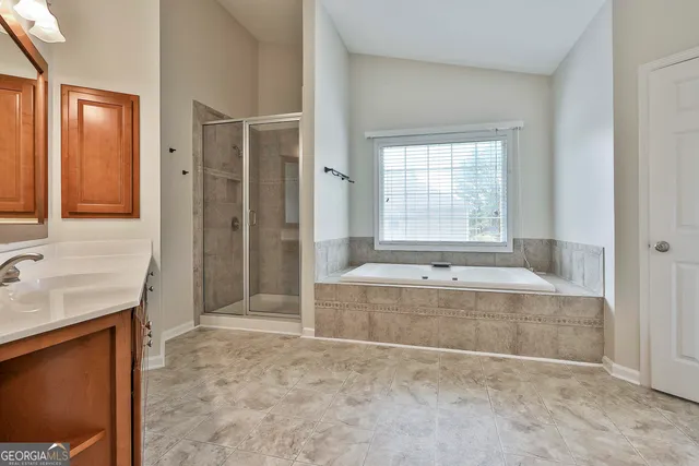 an empty room with windows and chandelier fan