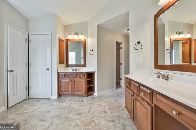 an empty room with windows and chandelier fan