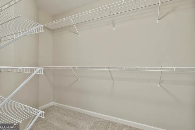a view of an empty room with a chandelier fan