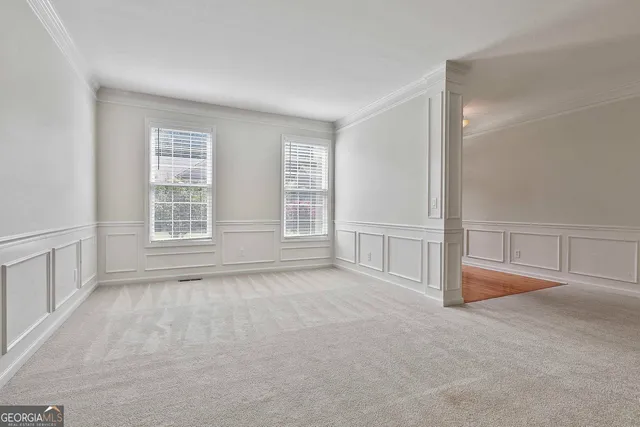 a view of a livingroom with a chandelier fan and windows
