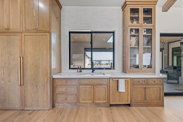 a kitchen with white cabinets and sink