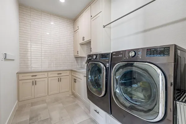 a utility room with sink dryer and washer