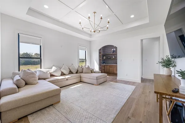 a living room with furniture a chandelier and a window