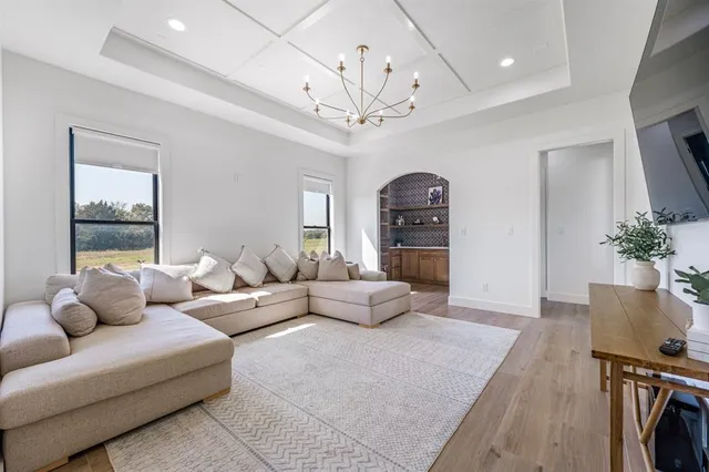 a living room with furniture a chandelier and a window