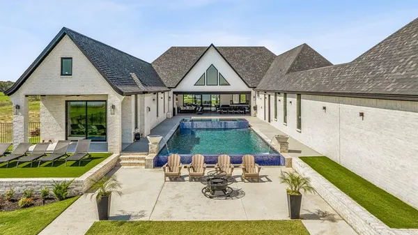 a view of house and yard with swimming pool and furniture