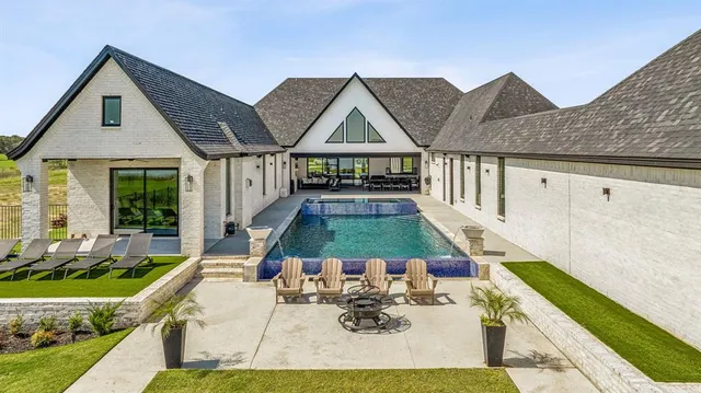 a view of house and yard with swimming pool and furniture
