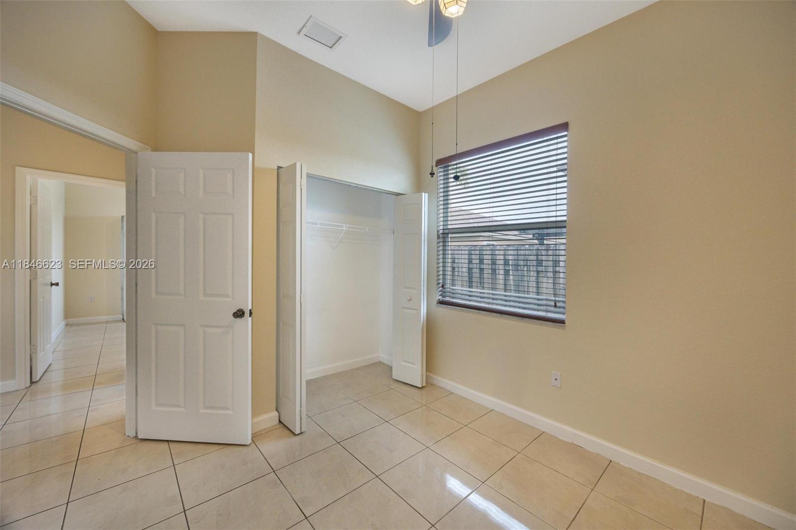 1780 Southeast 19th Terrace Homestead, FL 33035 - Photo 18 of 70 a view of an empty room with window and chandelier fan