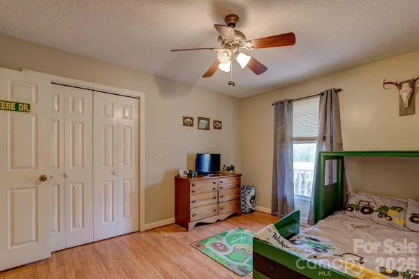 a bedroom with a bed and a chandelier fan