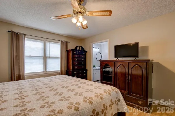 a bedroom with a bed and a flat tv screen on dresser