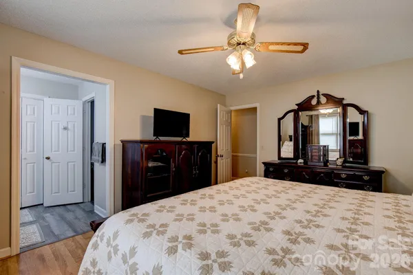 a bedroom with a bed and a flat tv screen on dresser