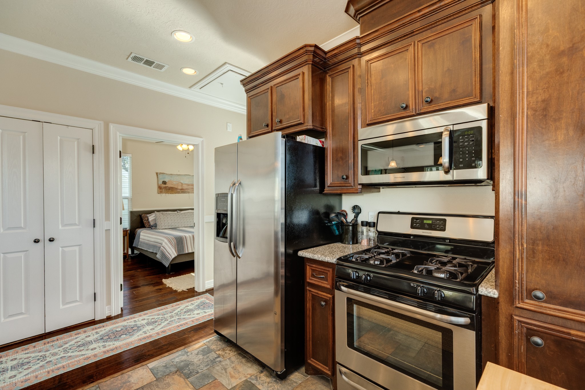 4317 Avenue R Galveston, TX 77550 - Photo 20 of 27 a kitchen with stainless steel appliances granite countertop a stove microwave and refrigerator