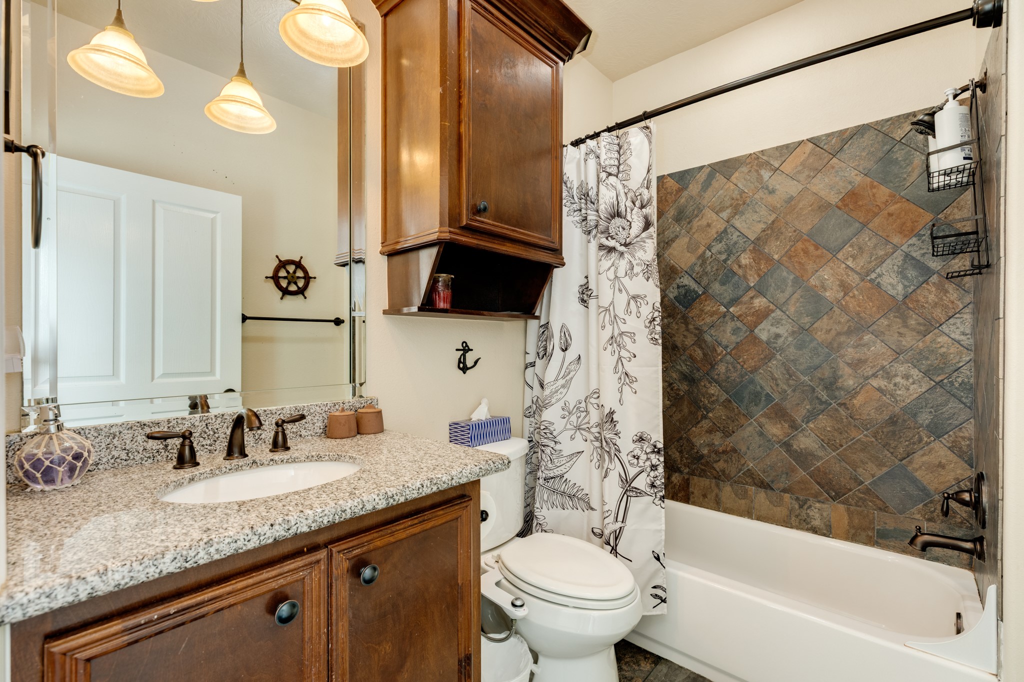 4317 Avenue R Galveston, TX 77550 - Photo 27 of 27 a bathroom with a granite countertop sink a toilet and a bathtub