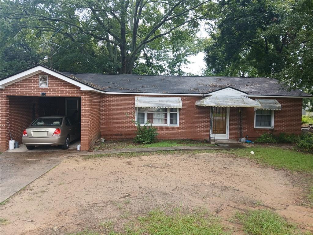 a front view of a house with a garden and trees