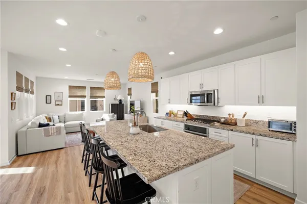 a kitchen with stainless steel appliances granite countertop a kitchen island a stove a table and chairs in it